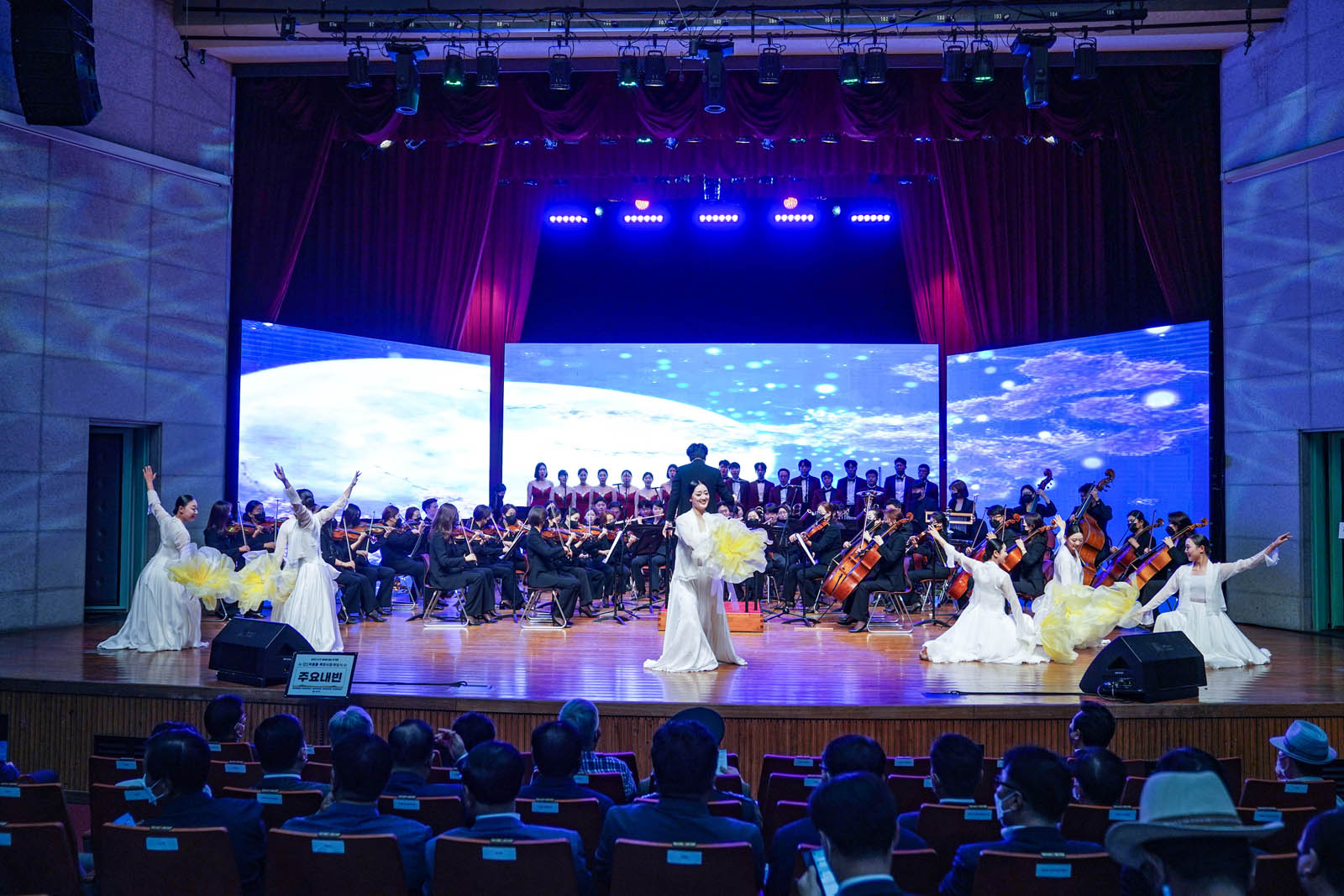 (07.01.문화예술회관) 취임식전 무대공연을 하는 모습으로 하얀 드레스를 입은 무용수들이 오케스트라 앞에서 공연을 하고 있다