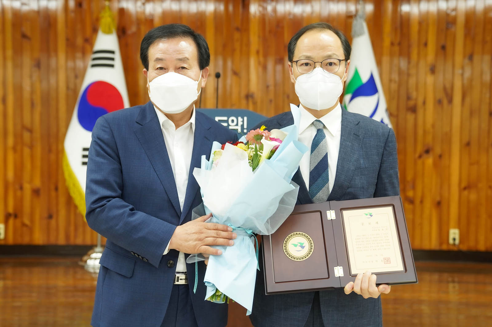 (07.05.회의실) 꽃다발을 들고있는 목포시장과 강효석 목포시부시장의 모습