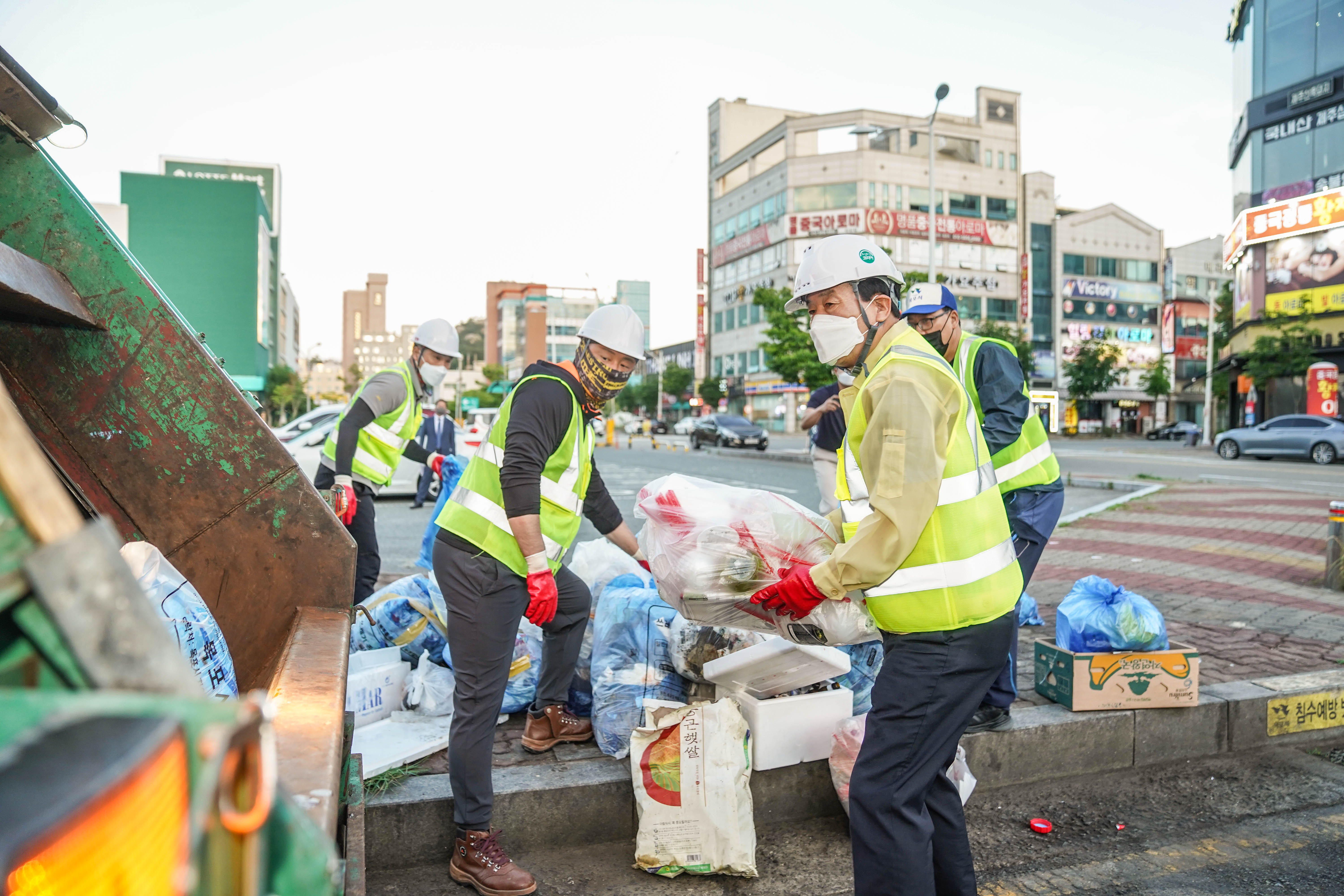 쓰레기가 담긴 봉투들을 쓰레기차에 옮기기 시작하는 목포시장과 환경미화원 분들의 모습
