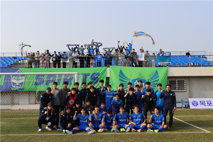 FC 목포 축구단 선수들이 팬들과 함께 모여서 사진을 찍고 있는 모습