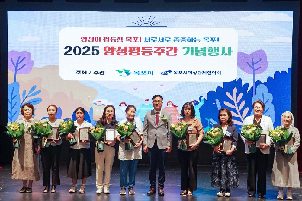 기념행사에서 수상자들이 패와 꽃다발을 들고 관계자와 함께 단체 기념 촬영을 하고 있는 모습이다.