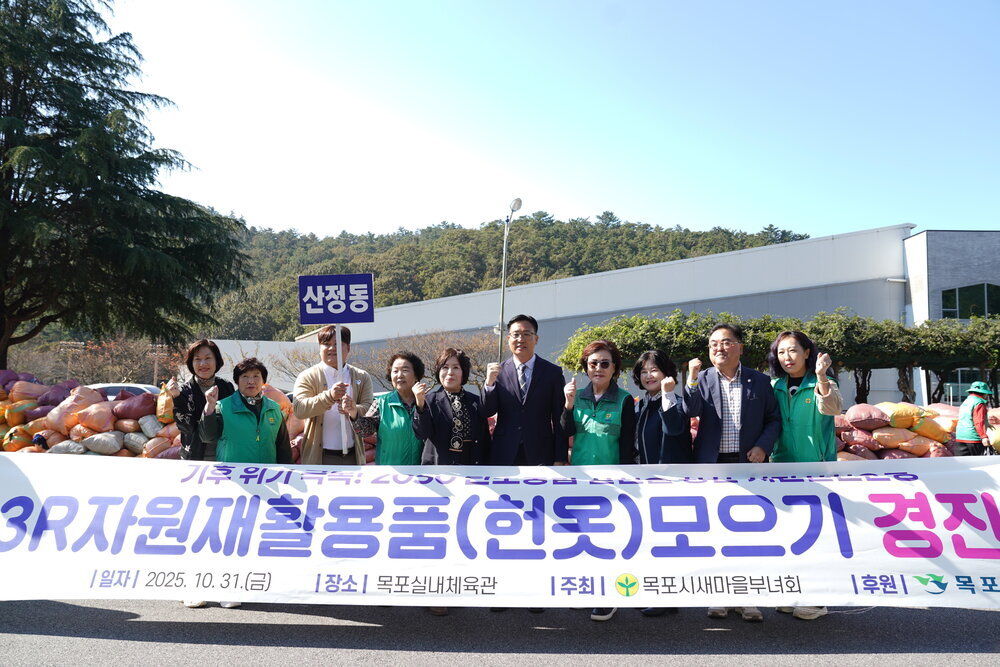 '목포시 새마을부녀회' 주최 헌옷 모으기 경진대회 현수막 앞에서 '연동' 표지판을 들고 단체 사진을 찍는 모습.