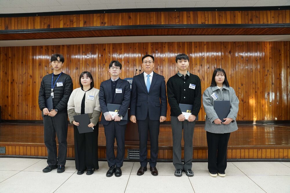 2월 정례조회 행사에서 정장을 입고 안경을 쓴 남성이 수상자들과 함께 기념촬영을 하고 있으며, 왼쪽부터 임성훈, 김초원, 이창민, 윤덕원, 정은애가 상장을 들고 일렬로 서 있다.