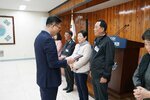 4월 정례조회에 정장을 입고 안경을 낀 남성이 검은색 점퍼를 입은 홍광순에게 패를 수여하고 있다